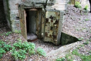 Picture of an Airsoft bunker or fort made in cement with a thick rock door swinging open