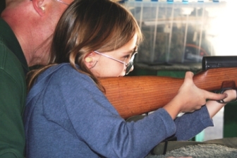 Picture of a father and a girl his daughter with a rifle gun related to teaching your children about guns and safety using Airsoft