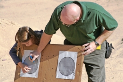 Photo of a girl father and daughter at target practice, learning how to use a gun via Airsoft safety
